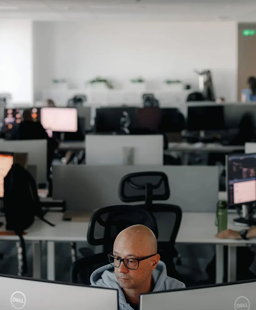 A man looking at two monitors