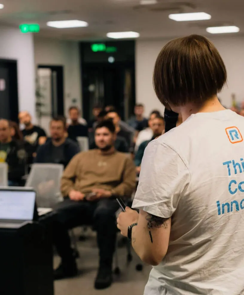 A woman wearing a shirt with the RingCentral logo speaking to a group of people
