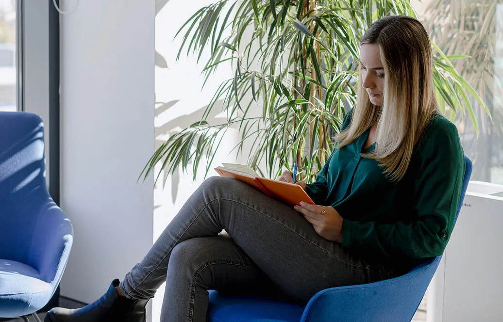 A woman sitting while reading a book