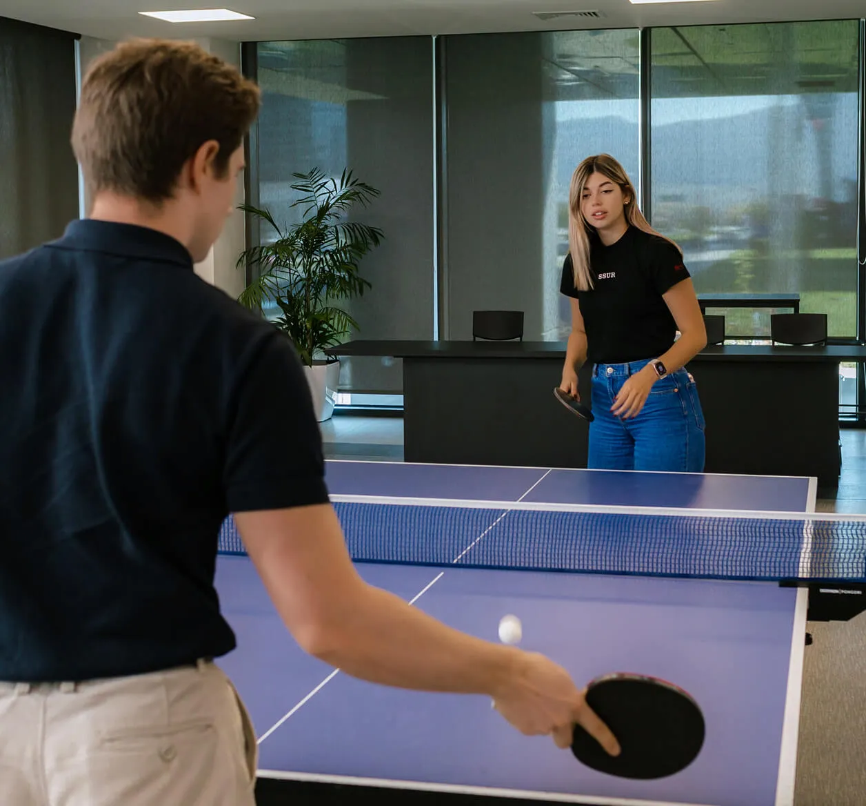 A male and female RingCentral employees playing table tennis