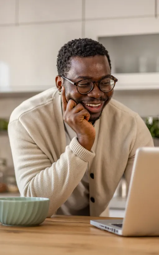 A man working from home using his laptop to join a meeting about his remote volunteering activities