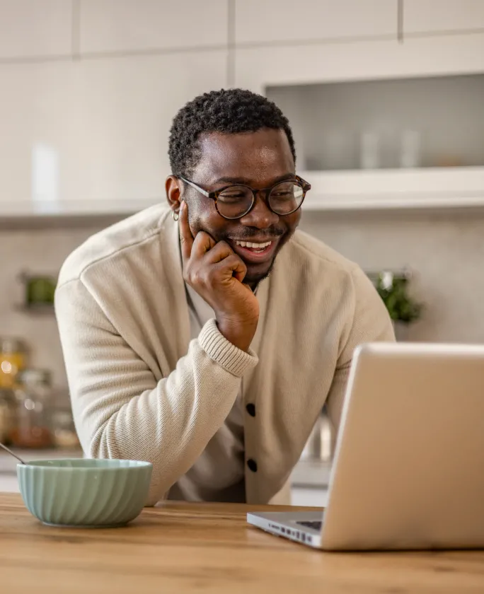 A man working from home using his laptop to join a meeting about his remote volunteering activities
