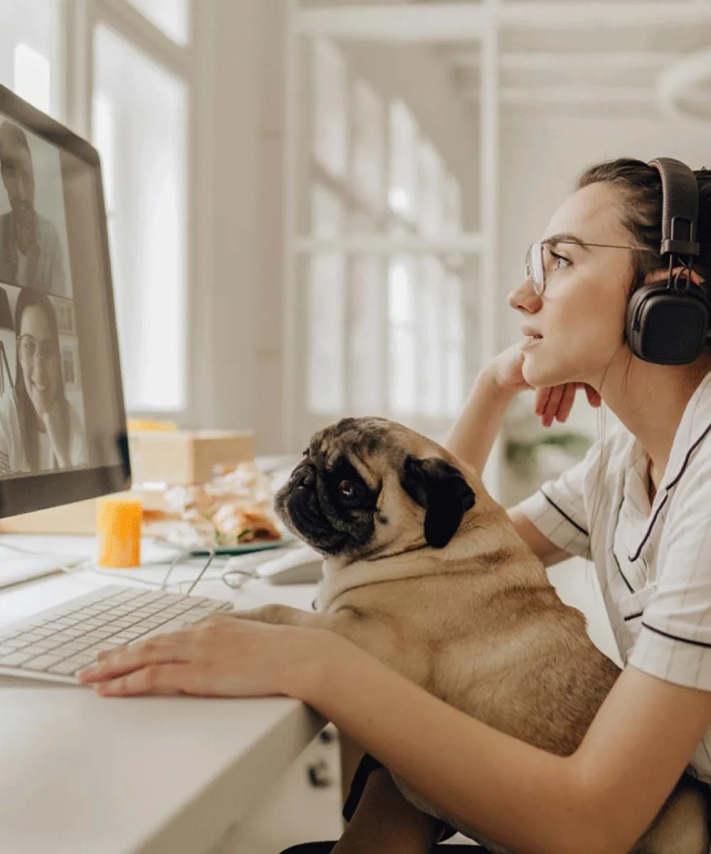 A woman and her dog attending a virtual meeting
