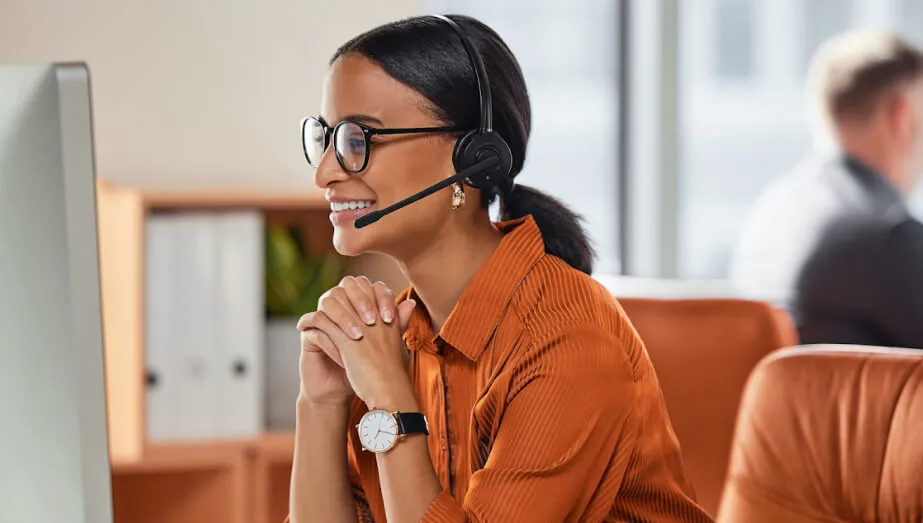 Customer support agent using a VoIP phone system with headset on a computer