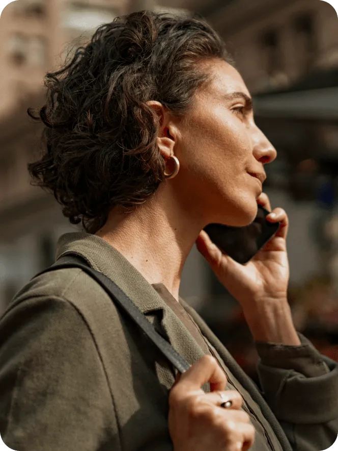 A woman holding her cellphone while outside