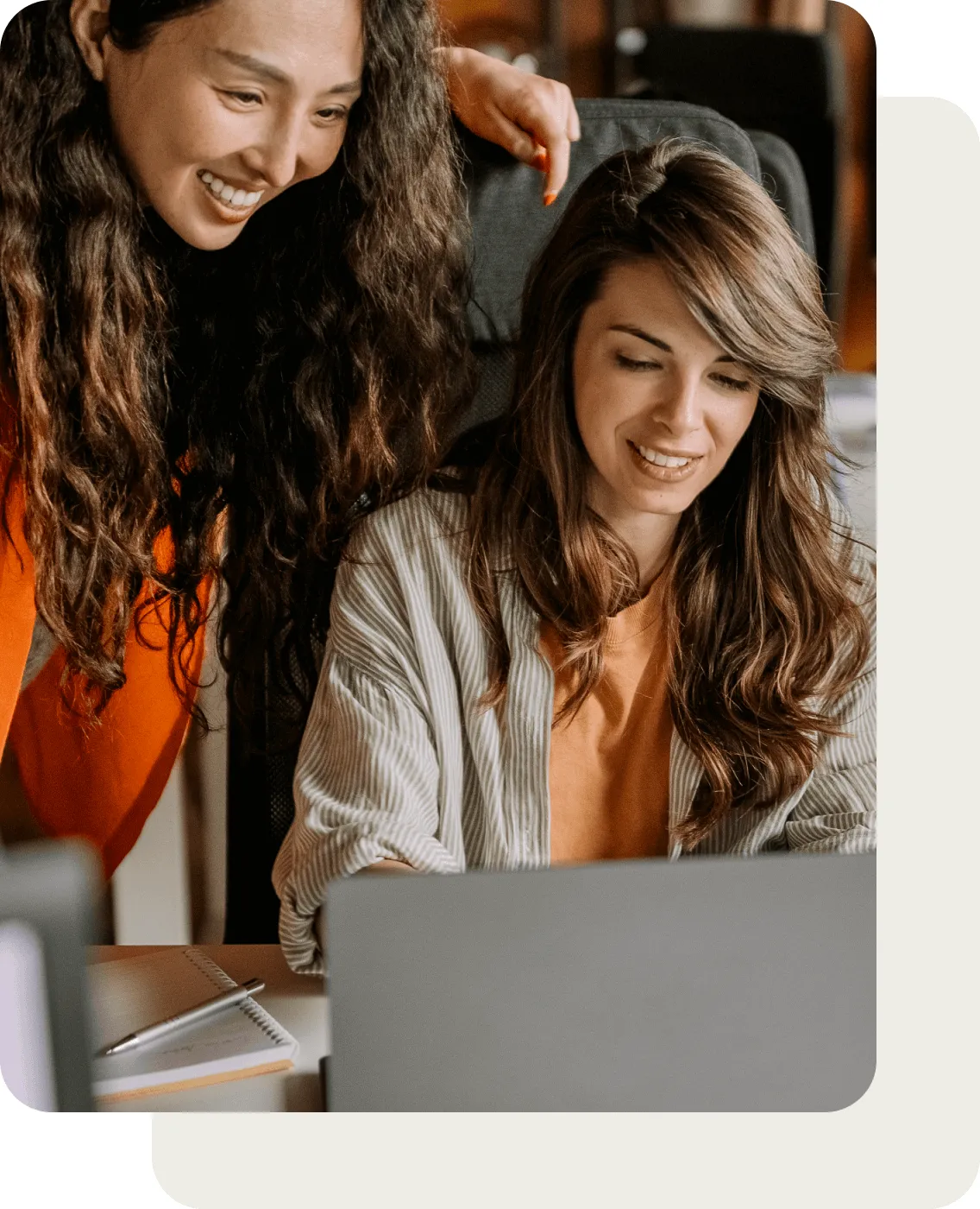 Two female colleagues looking at a laptop
