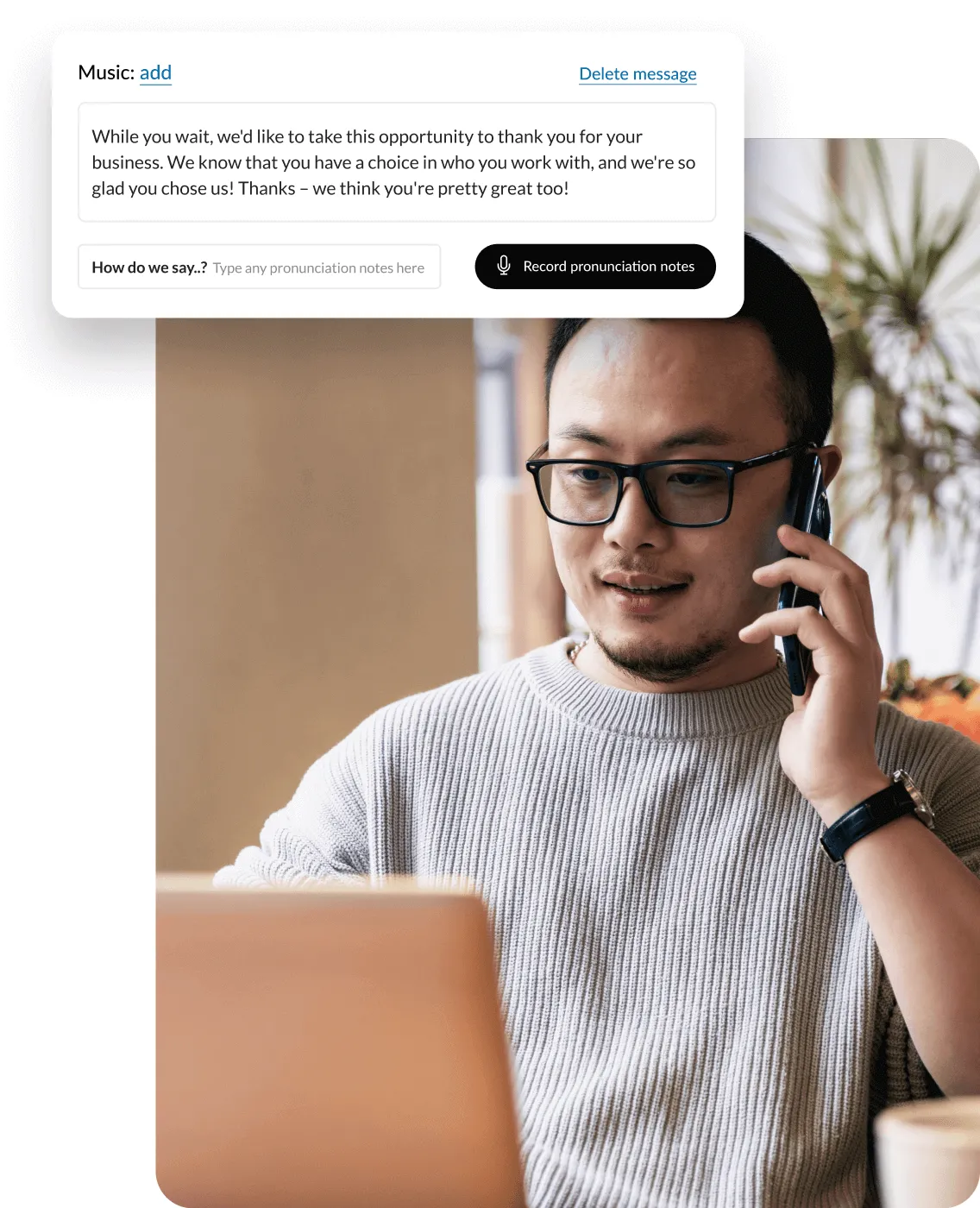 A man listening to a professionally recorded greeting on his phone while looking at his laptop