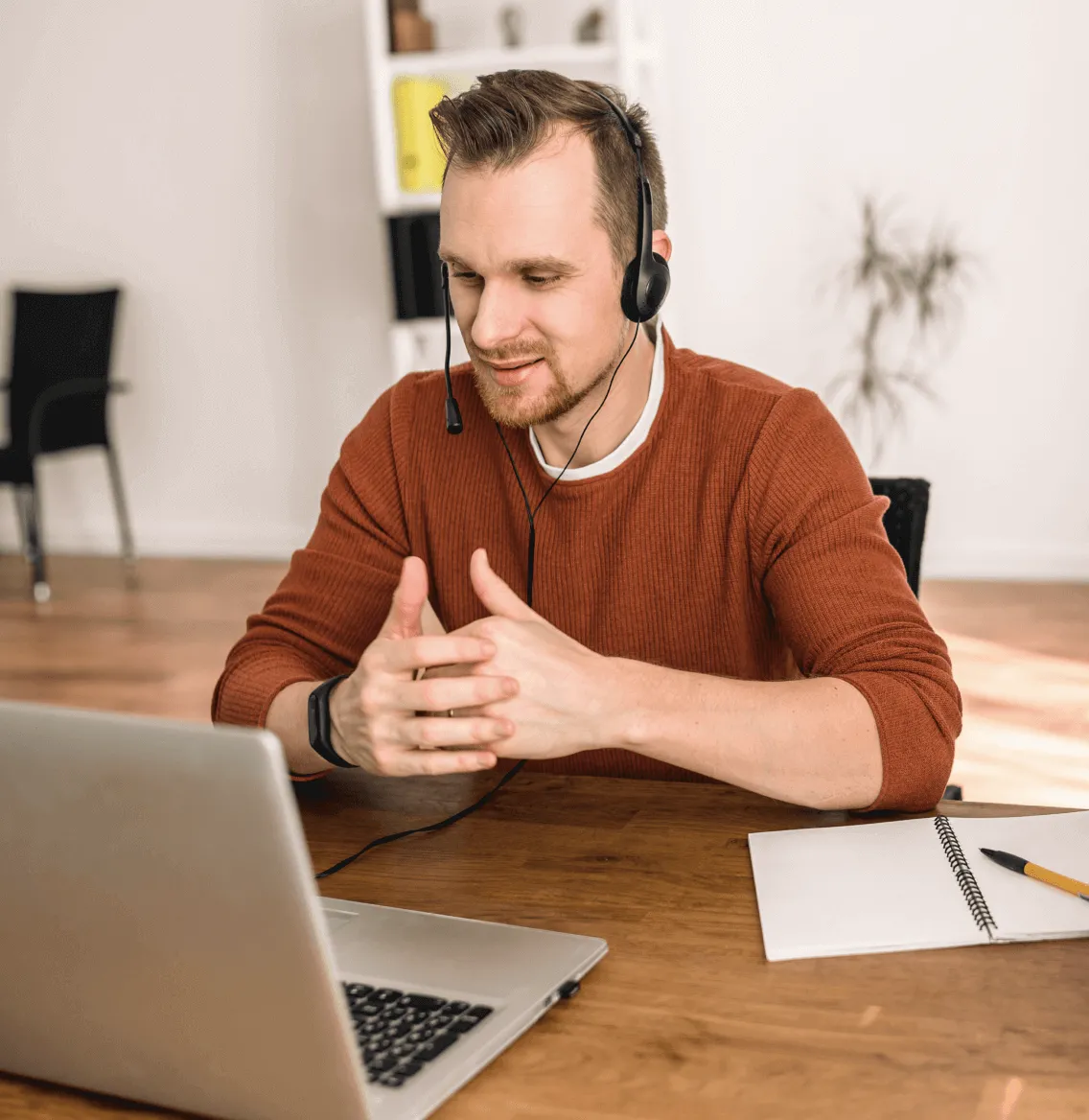A male agent wearing a headset working from home 