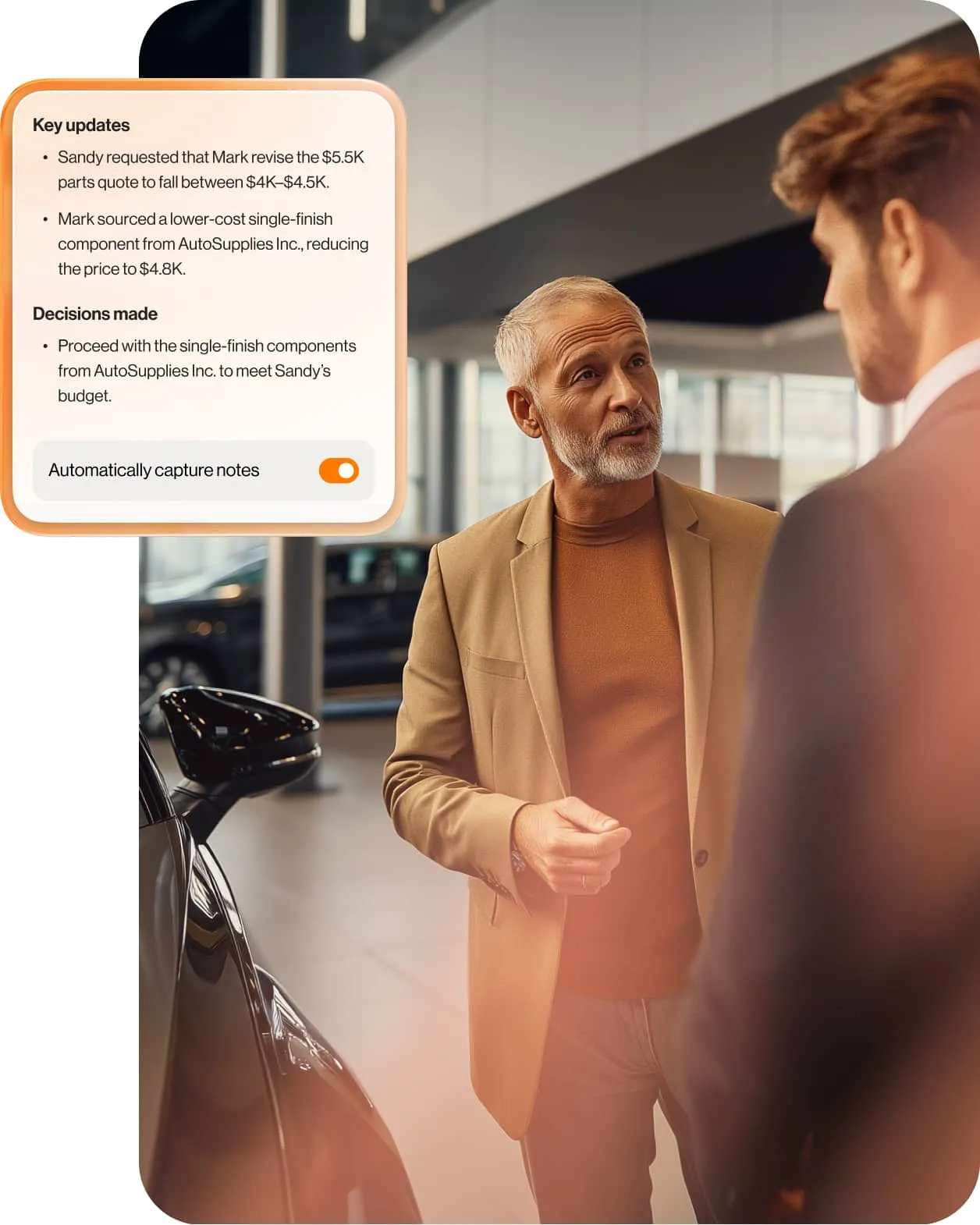 Dealership employee and a customer stand next to a car, talking.
