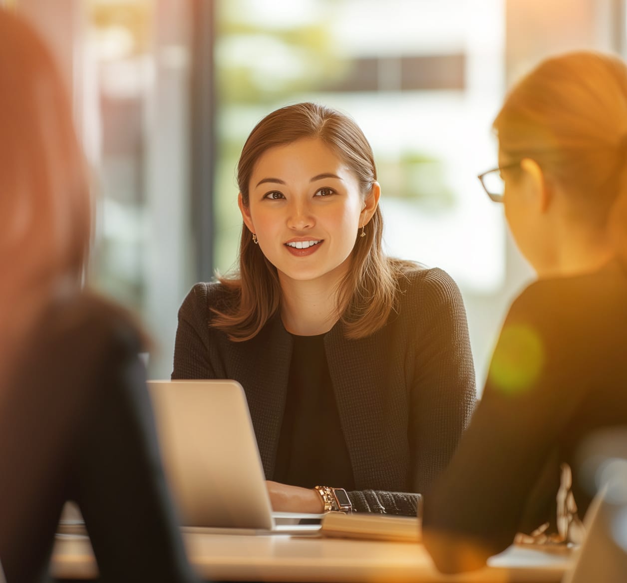 A female manager leading a discussion in an in-person business meeting.