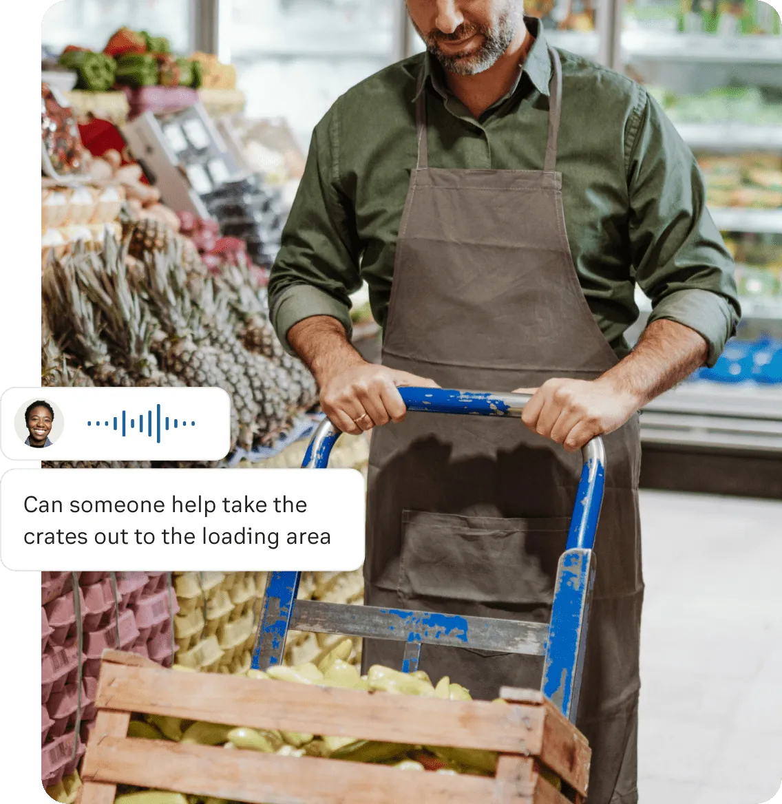 A male grocer pushing a trolley with a crate of fruit after push to talk message "can someone take the crates out to the loading area"