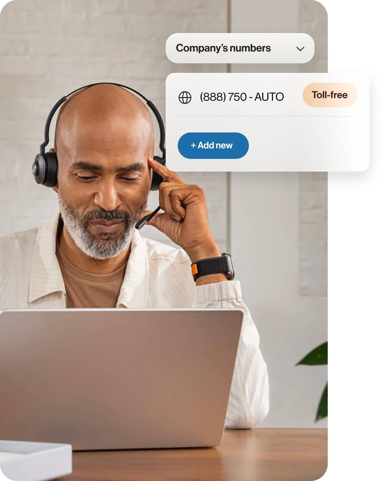 A man looking at a laptop with an insert of a toll-free number provided by RingCentral