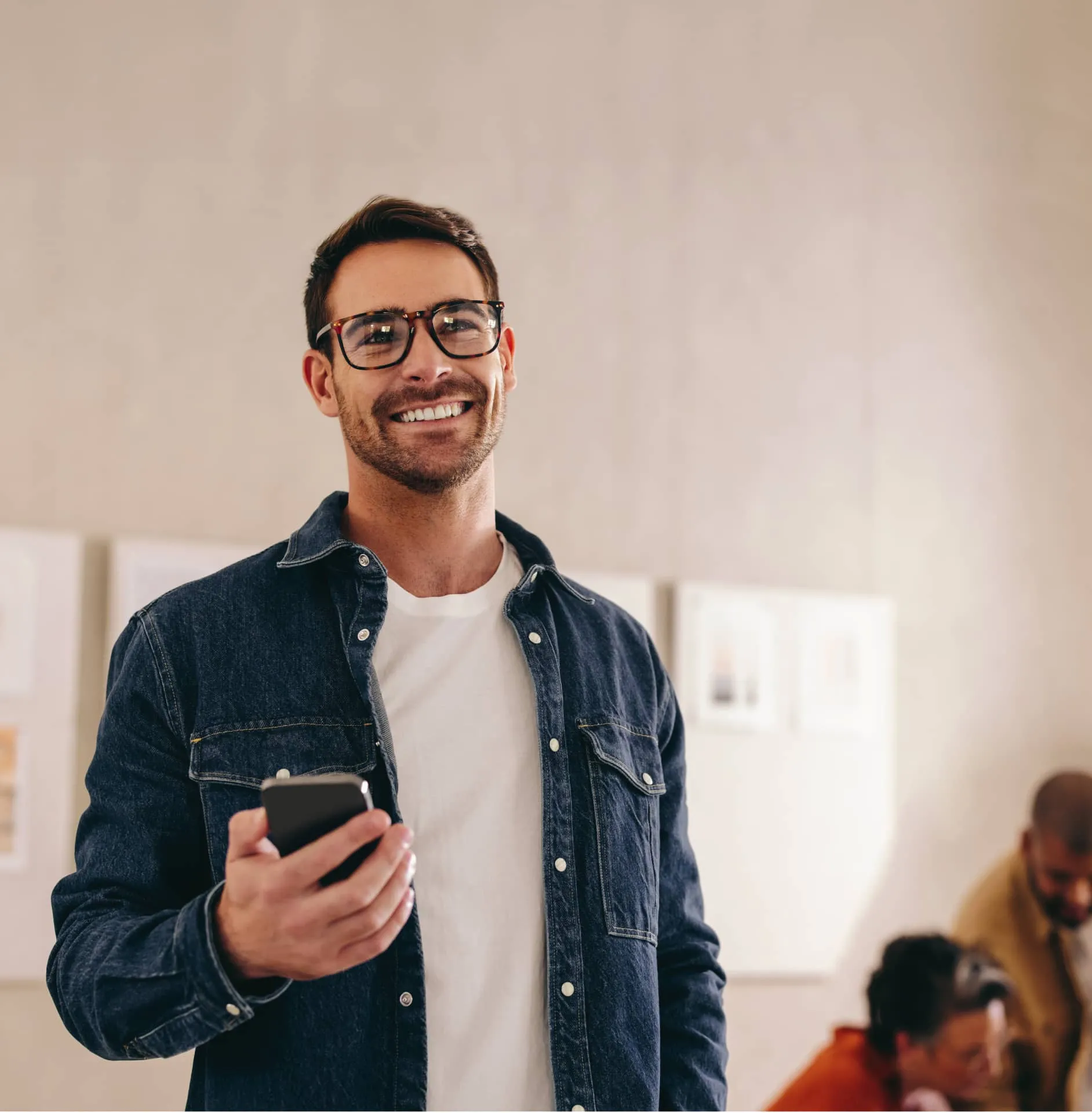 A man smiling while holding a mobile phone