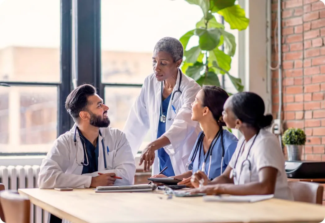 Four medical professionals collaborating around a table.
